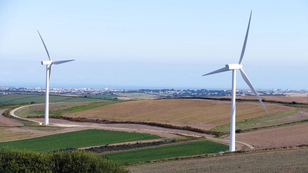 Zwei Windenergieanlagen in einer Ackerlandschaft