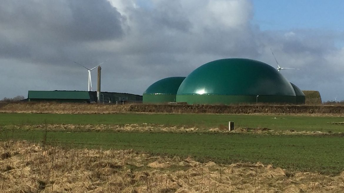 A biogas plant set against a cloudy sky