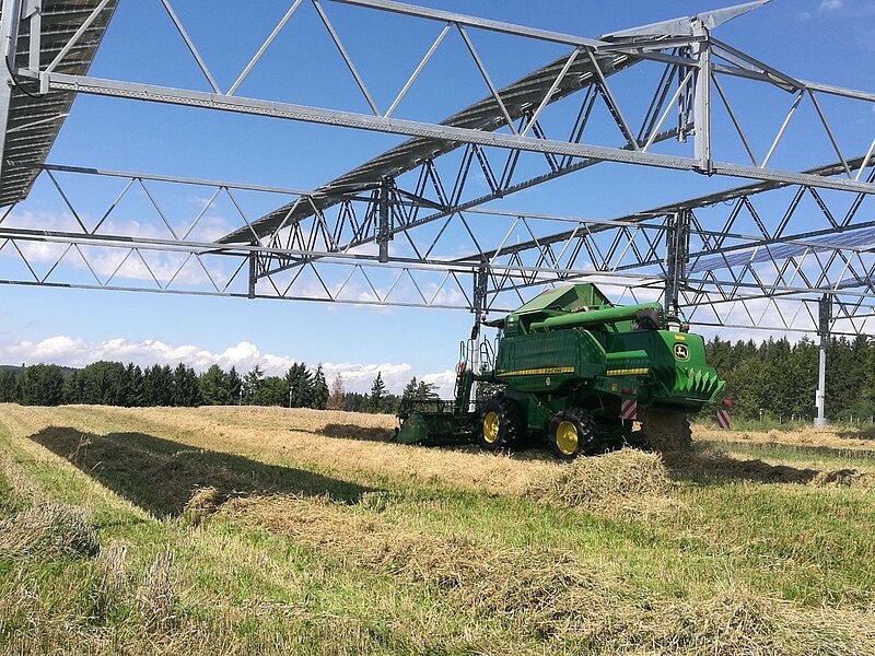 Agricultural utility vehicle cultivates a field under a PV elevation