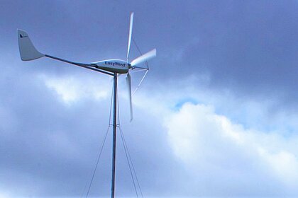 A small wind turbine against a cloudy sky