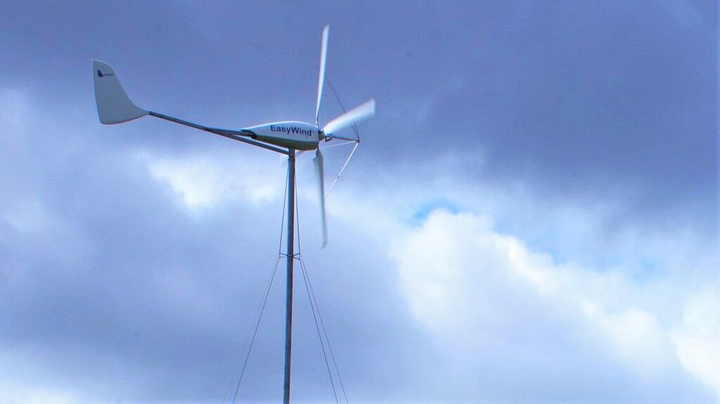 A small wind turbine against a cloudy sky