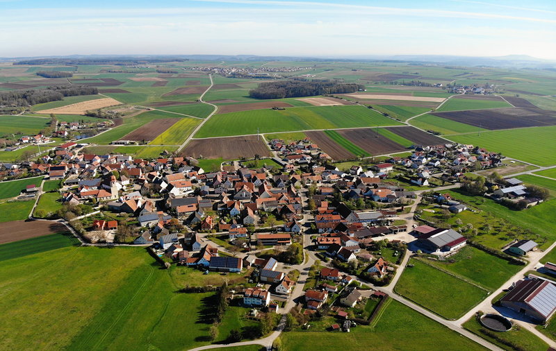 Aerial view of a village with many solar roofs.