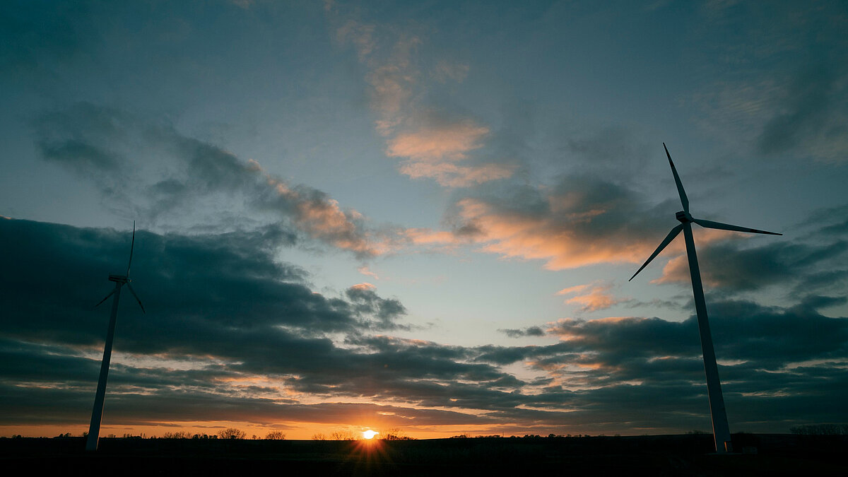Windenergieanlagen vor einem bewölkten Abendhimmel