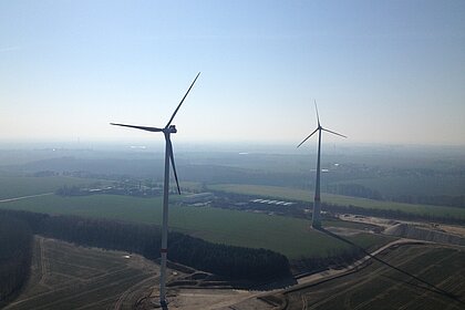 ein Luftbild zeigt zwei Windräder in flacher Landschaft