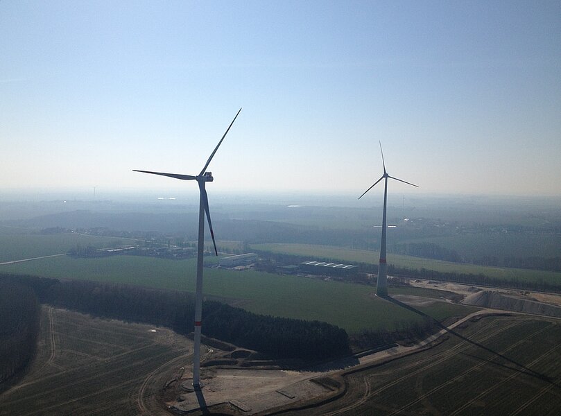 ein Luftbild zeigt zwei Windräder in flacher Landschaft
