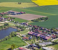 Ein Luftbild der Gemeinde Bollewick, Solaranlagen und eine Biogasanlage sind zu sehen